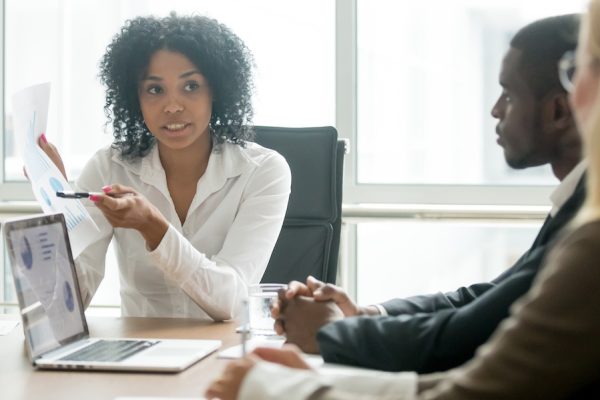 African businesswoman showing good statistics report explaining deal advantages convincing multiracial partners at negotiations meeting, black manager consulting diverse clients promising benefits